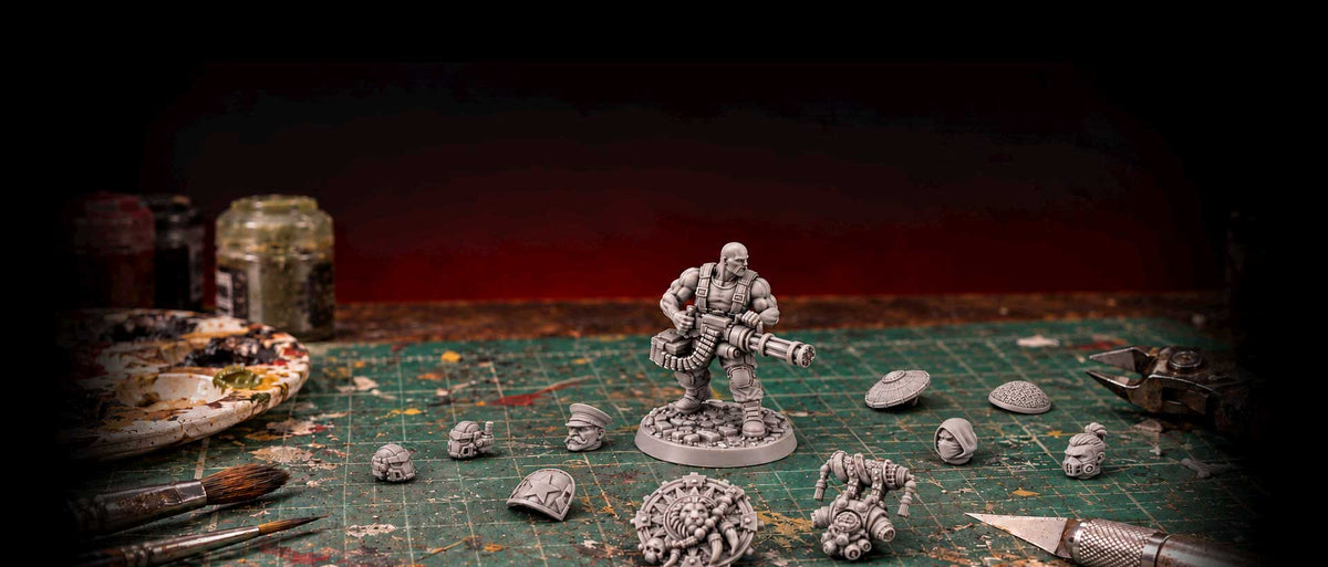 Grey resin miniature heads and helmets around a soldier miniature on a hobby mat